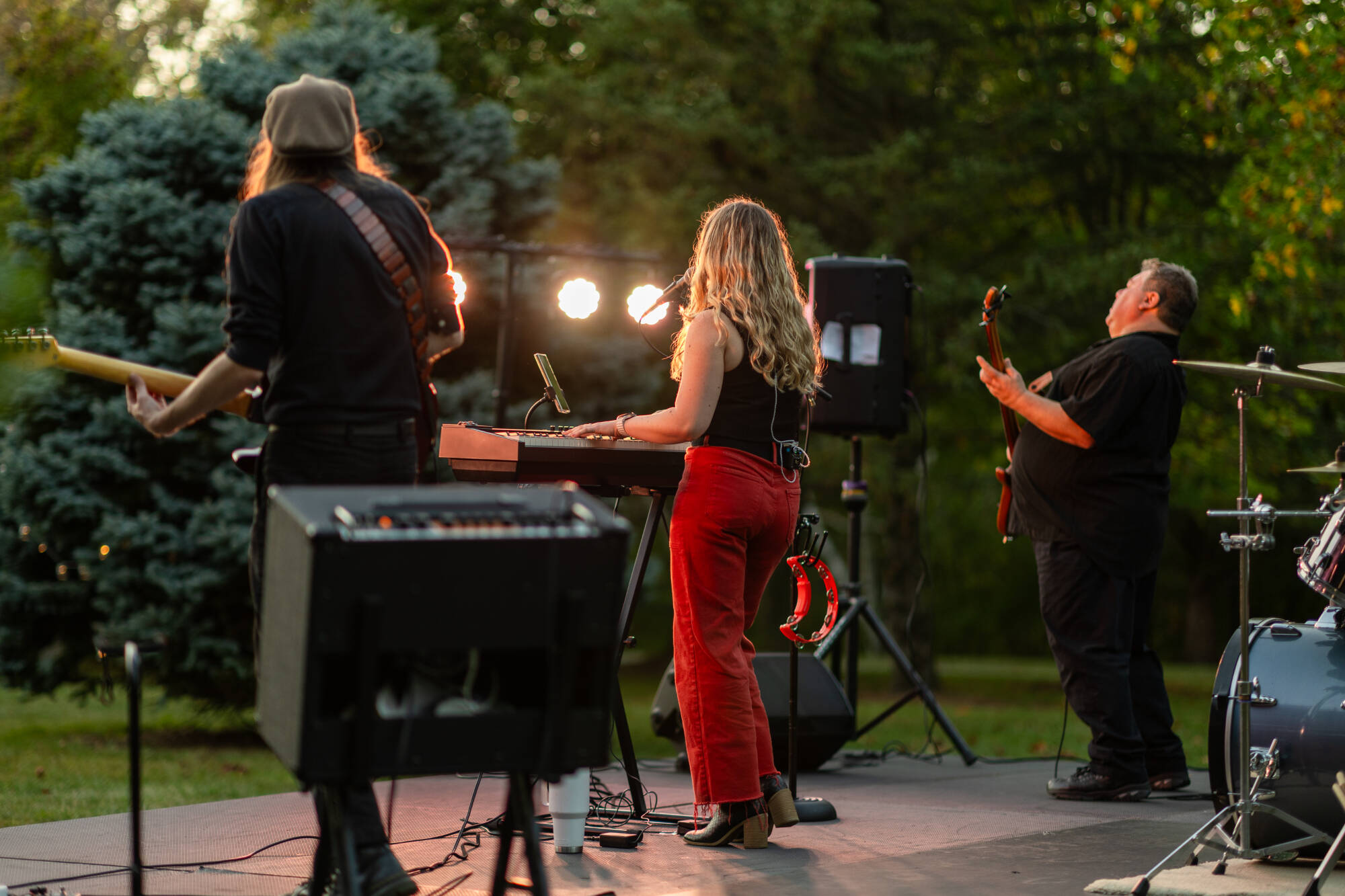 A group of people standing on stage in the Arboretum, playing music